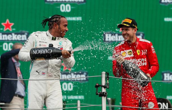 El británico Lewis Hamilton (i) de Mercedes celebra al ganar el Gran Premio de México de Fórmula Uno con al alemán Sebastian Vettel. /EFE/José Méndez