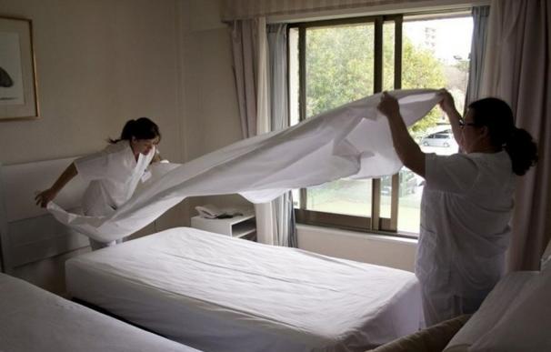 Dos limpiadoras trabajan en un hotel. / EFE