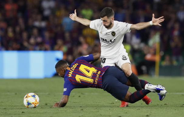 El jugador brasileño del FC Barcelona Malcom cae ante la presión de Jose Gayá, del Valencia CF, durante la final de la Copa del Rey. /EFE