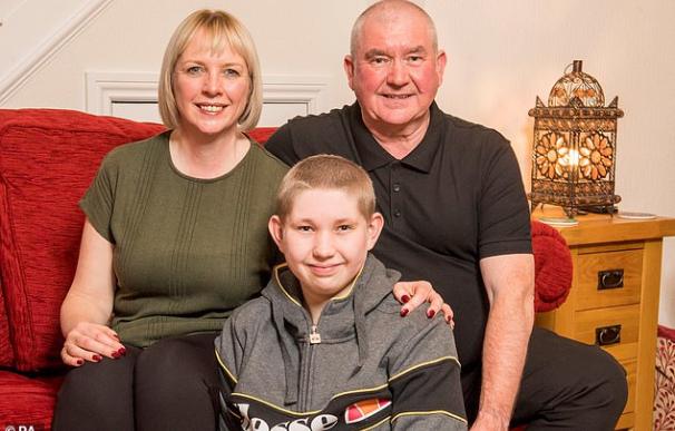 Fotografía de John y Allison McDonald junto a su hijo Ewan, que superó un cáncer.