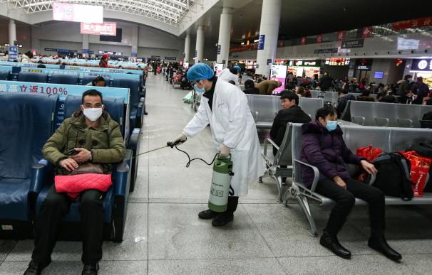 Un operario desinfecta una zona de espera para pasajeros en la estación de tren de Nanchang, en la provincia china de Jiangxi. /EFE
