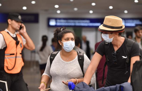 Personas con mascarillas en el aeropuerto de Buenos Aires.