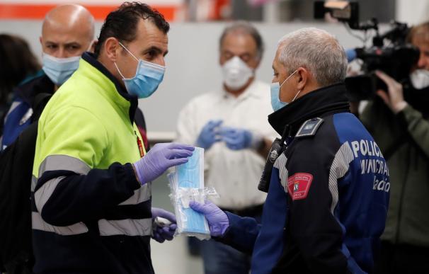 Policías entregan mascarillas en la estación de metro de Nuevos Ministerios en Madrid, este lunes. Según anunció el pasado sábado el ministro de Sanidad, Salvador Illa, las fuerzas de seguridad repartirán 10 millones de mascarillas este lunes a los trabaj