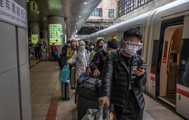 Decenas de pasajeros llegados de Wuhan en una estación de Pekín. / EFE