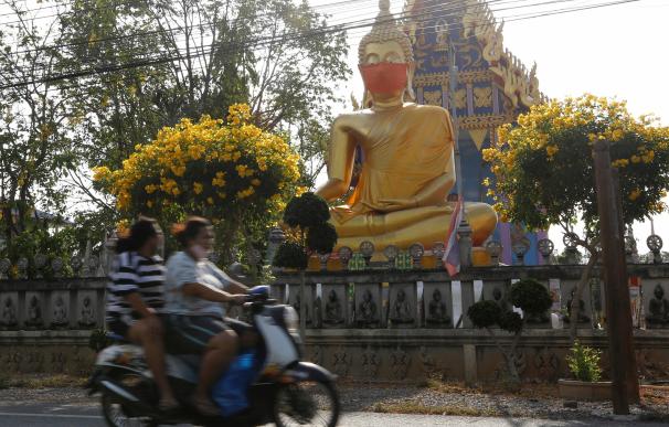 Imagen de una estatua de Buda con mascarilla en la afueras de Bangkok