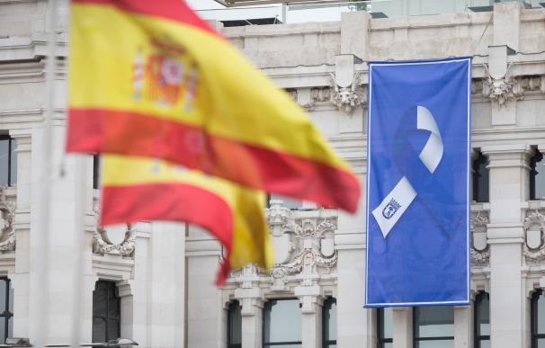 Bandera de España y bandera con el lazo que simboliza la lucha unida del pueblo de Madrid en la fachada del Ayuntamiento de Madrid
