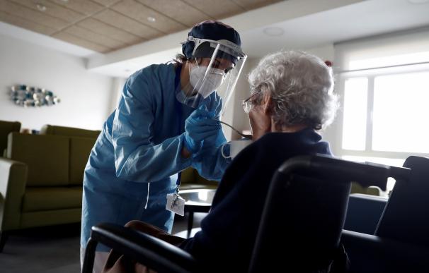 Un sanitario atendiendo a una mujer anciana