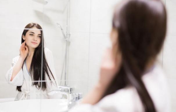 Una joven se mira al espejo