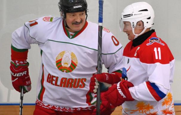 El presidente bielorruso, Alexander Lukashenko, charla con el ruso, Vladimir Putin, en un partido de hockey sobre hielo.