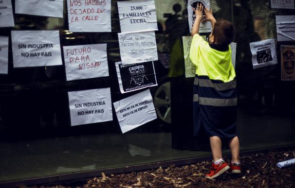 El hijo de un trabajador de las plantas que cerrarán de Nissan en Barcelona participa en una protesta.