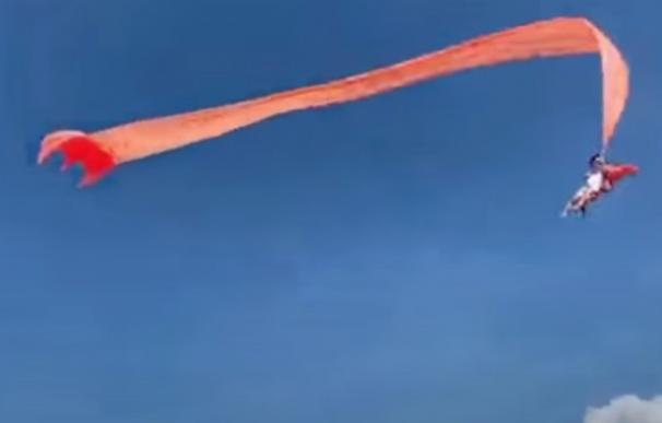 Una niña de tres años sale volando con su cometa por el fuerte viento