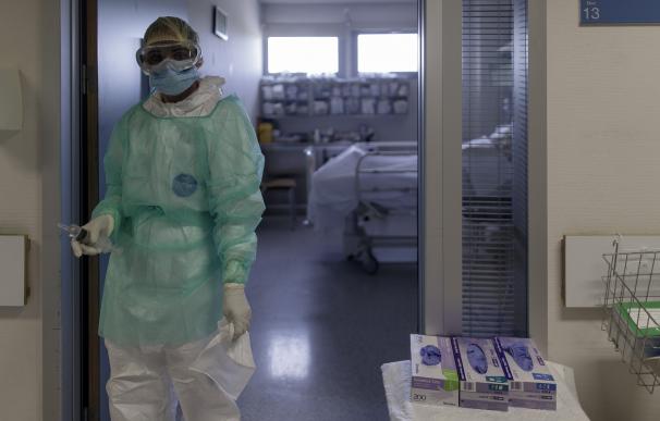 Un trabajador sanitario, en la puerta de una habitación de UCI en un hospital madrileño.