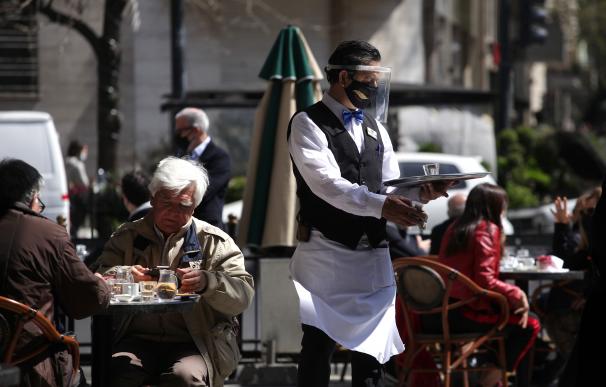 Un camarero atiende a los clientes en una terraza de Buenos Aires.