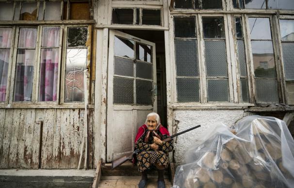 Una anciana sostiene un arma en la puerta de su casa en la localidad e Stepanakert, en pleno conflicto de Nagorno Karabaj.