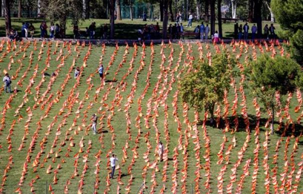 Varias personas visitan el Parque de Roma de Madrid, junto a la M-30, en el que se han colocado un total de 53.000 banderas de España en homenaje a los españoles fallecidos por coronavirus, en Madrid