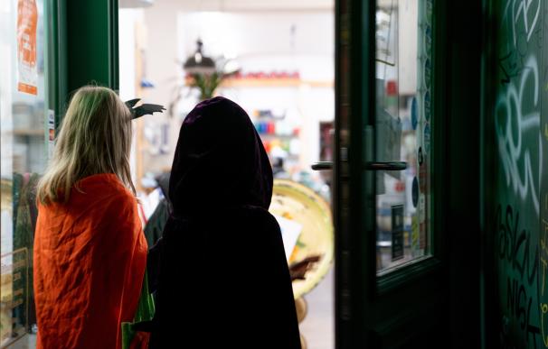 Niños disfrazados entran en una tienda para pedir dulces la noche de Halloween en Berlín