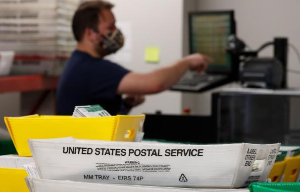 Un trabajador del servicio postal de Estados Unidos tramita varias papeletas en Utah.