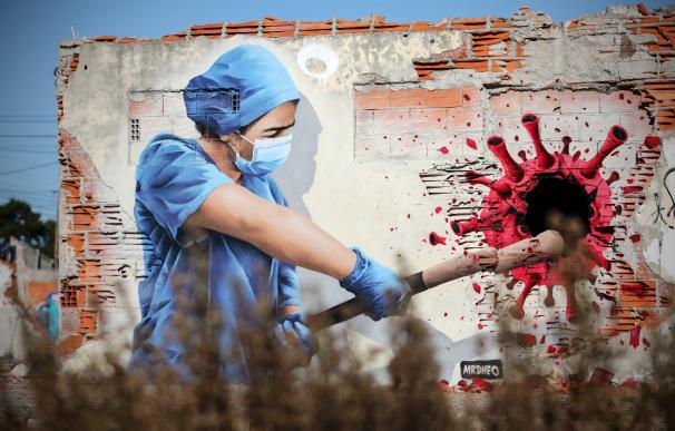 Un grafiti del artista callejero MrDheo representa a una sanitaria golpeando al virus de la Covid-19, este viernes en las afueras de Vila Nova de Gaia, en el norte de Portugal.