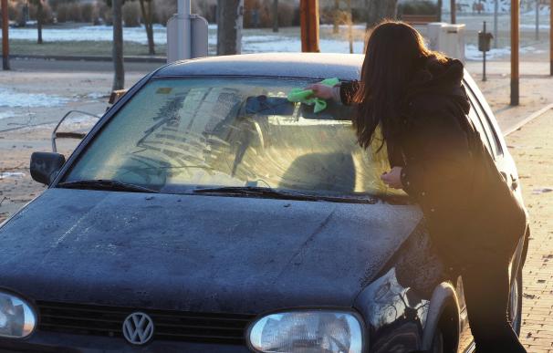 Una mujer retira el hielo de su vehículo esta mañana en Arroyo de la Encomienda (Valladolid). La primera ola de frío del año alcanza este martes su punto álgido con mínimas que oscilarán entre los 16 y 12 grados bajo cero en amplias zonas del interior peninsular.