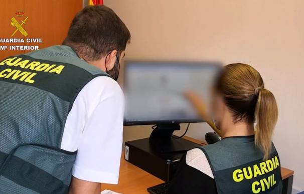 Dos agentes de la Guardia Civil repasan el perfil falso