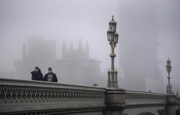 05 November 2020, England, London: Two men wearing face masks walk over Westminster Bridge amid foggy conditions at the start of a four-week national lockdown for England. Photo: Victoria Jones/PA Wire/dpa (Foto de ARCHIVO) 5/11/2020 ONLY FOR USE IN SPAIN