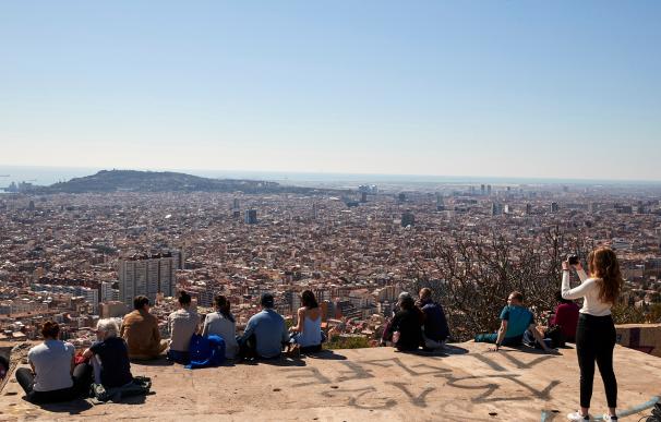 Varias personas observan el paisaje mientras visitan los búnker del Turó de la Rovira durante el puente de San José en Barcelona.