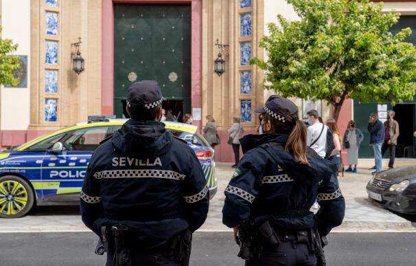 Dos policías locales pendientes de  la cola en la Basílica del Stmo. Cristo de la Expiración de Sevilla.
