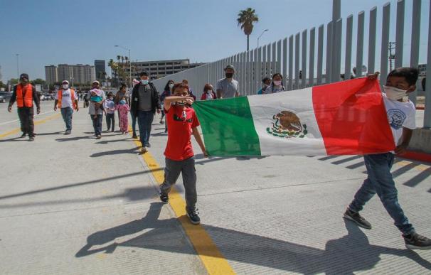 Familias de migrantes marchan hoy en las inmediaciones del cruce fronterizo de El Chaparral, en Tijuana (México)