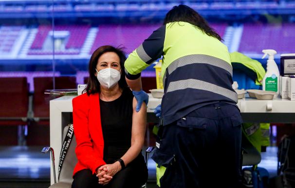 Un sanitario vacuna a la ministra de Defensa, Margarita Robles en el Wanda Metropolitano, en Madrid.