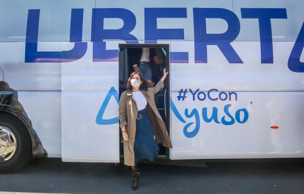 La presidenta de la Comunidad de Madrid y candidata a la reelección, Isabel Díaz Ayuso, con los autobuses de campaña electoral.