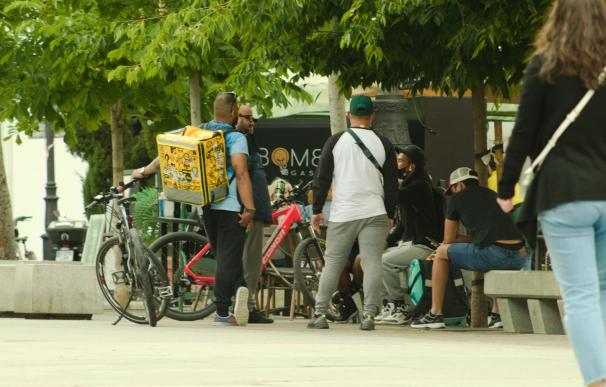 Grupo de repartidores o 'riders' en la plaza de Santa Ana, Madrid (España).