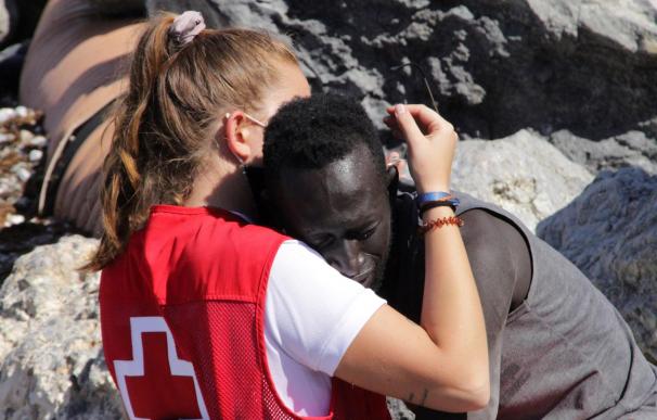 Una cooperante de Cruz roja abraza a un migrante recién llegado a Ceuta