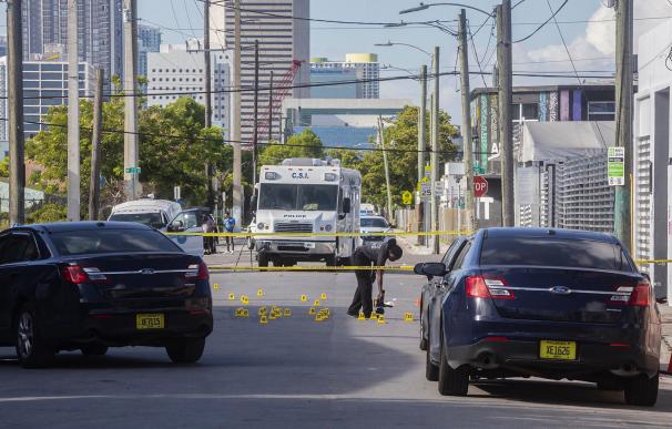 Una policía investiga la escena del crimen en Miami donde mataron a dos personas e hirieron a 20.