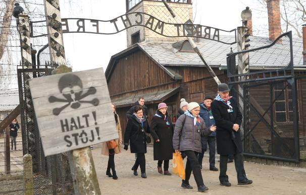 Exprisioneros del campo de concentración de Auschwitz marchan a través de sus puertas en el 75 aniversario de su liberación.