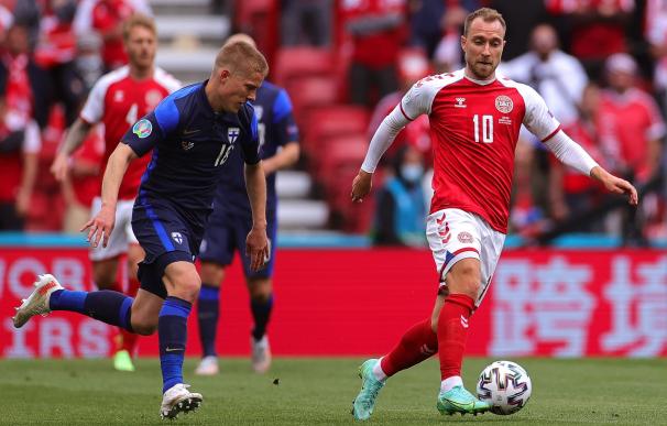 Christian Eriksen, del equipo de Dinamarca, se enfrenta al finlandés Jere Uronen en el partido de la Eurocopa.