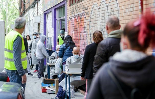 Cientos de personas sin recursos hacen cola en Aluche en busca de "una bolsa de comida".