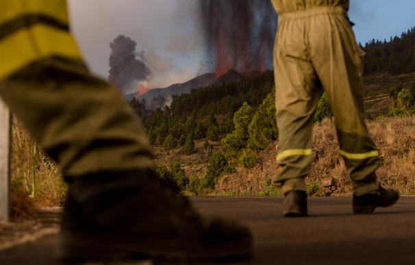 Los bomberos desplazados a La Palma observan el lento pero imparable avance de la lava en la zona más próxima del volcán.