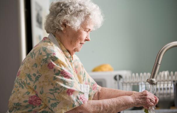 Mujer pensionista en la cocina de su casa.