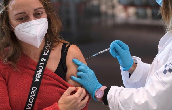 Una mujer recibe una dosis de la vacuna de Moderna durante la jornada especial de vacunación de refuerzo contra la covid-19 para menores de 65, este domingo en el Palacio de Deportes de La Guía de Gijón.