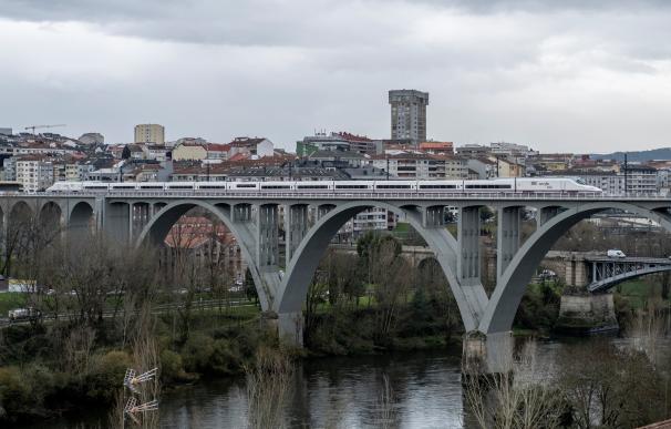 El tren inaugural de la primera línea de alta velocidad a Galicia, con el rey Felipe VI y el presidente del Gobierno, Pedro Sánchez, a bordo, cruza un puente en Ourense.