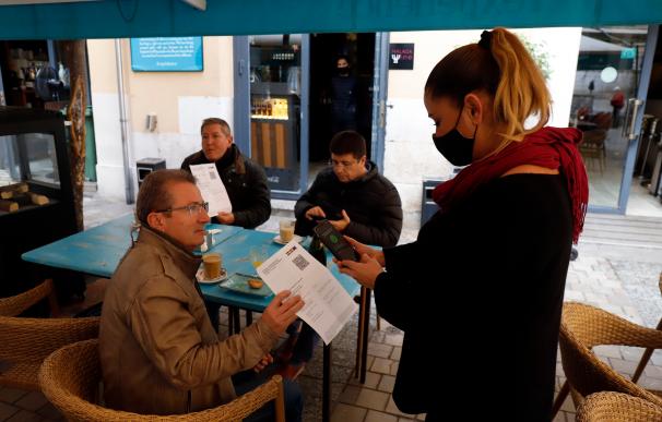 Una camarera pide certificado a los clientes en una mesa en la terraza de un bar durante el primer día de petición de Certificados Covid-19 para la hostelería, a 20 de diciembre de 2021 en Málaga (Andalucía, España) Álex Zea / Europa Press 20/12/2021