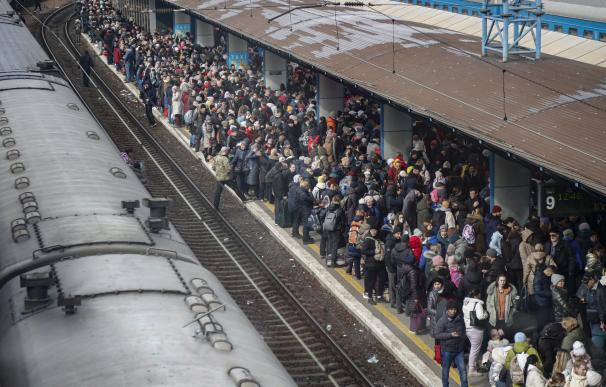 Numeroso público se reúne en la estación principal de tren mientras intentan huir de Kiev, Ucrania,