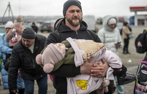 Un hombre con un niño en brazos en el paso fronterizo de Porubne, a 5 de marzo de 2022, en el oeste de Ucrania. Según las últimas informaciones, Ucrania suspendió hoy la evacuación de civiles de Mariupol ante la ruptura del alto el fuego, para abrir corredores humanitarios, por parte de Rusia. El balance de la guerra según el Servicio Estatal de Emergencia de Ucrania, es de más de 2.000 civiles muertos y más de un millón de refugiados que han huido del país. El Consejo de Seguridad de la ONU celebró una reunión de urgencia para denunciar que el ataque a la central nuclear de Zaporiyia, es ilegal. A pesar de la gravedad del ataque, no se han registrado cambios en los niveles de radiación. Lorena Sopêna / Europa Press 05/3/2022
