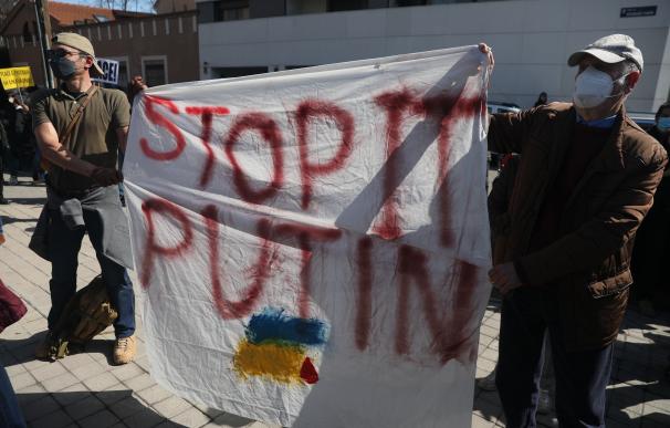 Dos hombres, con una pancarta que reza 'Stop Putin', participan en una manifestación en Madrid contra la guerra en Ucrania.