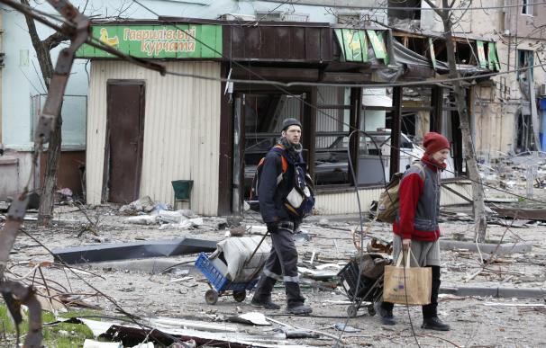 MARIUPOL, April 19, 2022 -- Residents walk near damaged buildings in Mariupol on April 18, 2022.