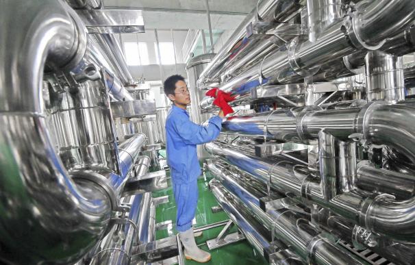 Un empleado limpia unos equipos en una fábrica de vinos en Weifang, China.