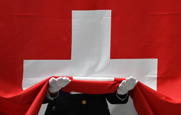 Un soldado recoge la bandera de Suiza.
