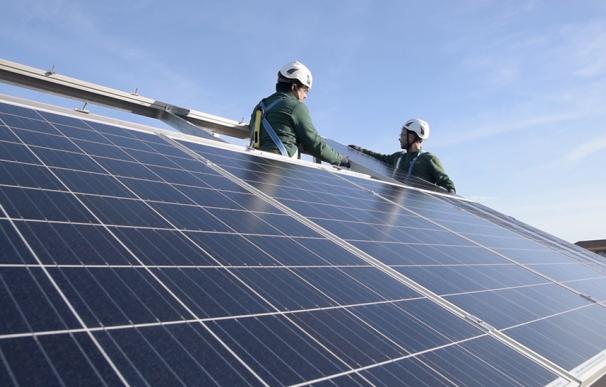 Dos operarios instalan placas solares.