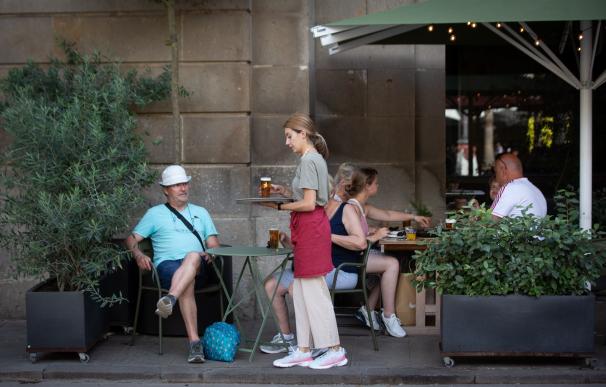 Una camarera sostiene una bandeja en la plaza Real de Barcelona.