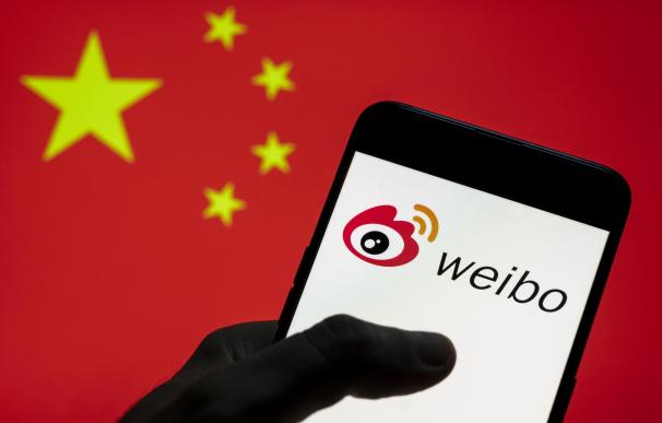 Bandera china y logotipo de Weibo en un teléfono móvil